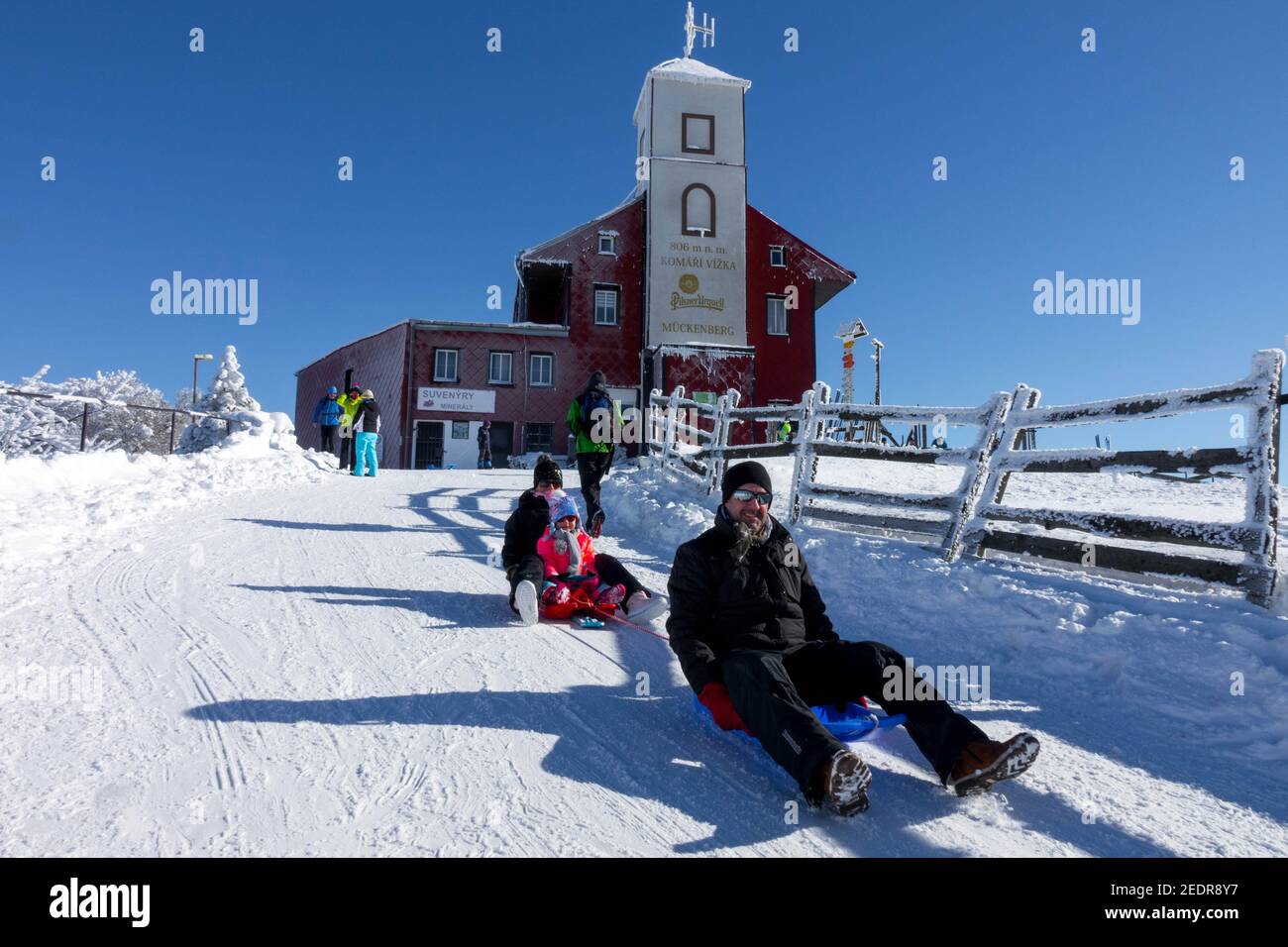 Repubblica Ceca lifestyle famiglia sledding in inverno il resort di montagna Komari Hurka bellow chalet di montagna bel tempo, gente felice Foto Stock