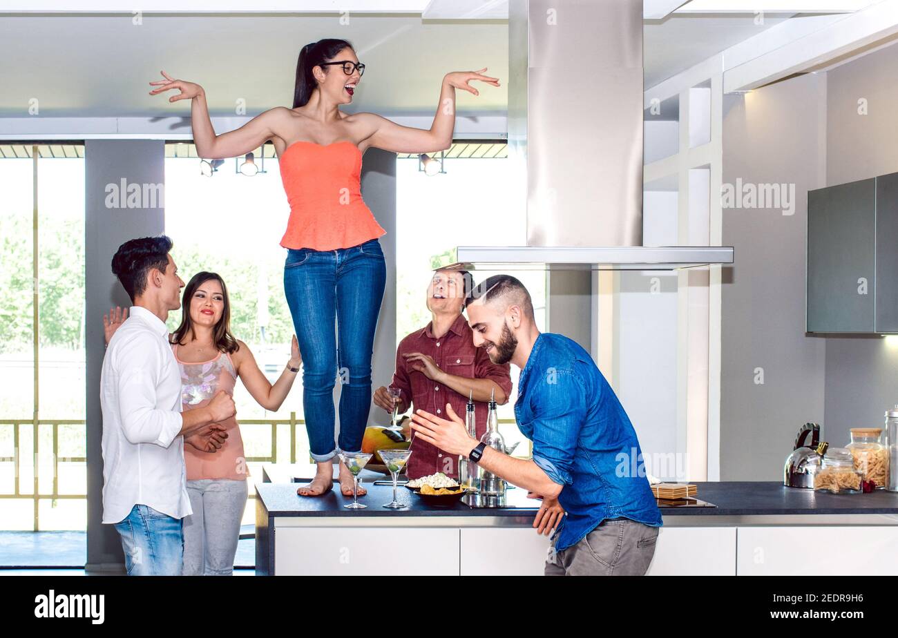Donna che danzava a tavola con un gruppo di amici al cocktail di casa Bar con aperitivo prima di cena nell'happy hour - ubriaco gente pazza che passa il tempo insieme Foto Stock