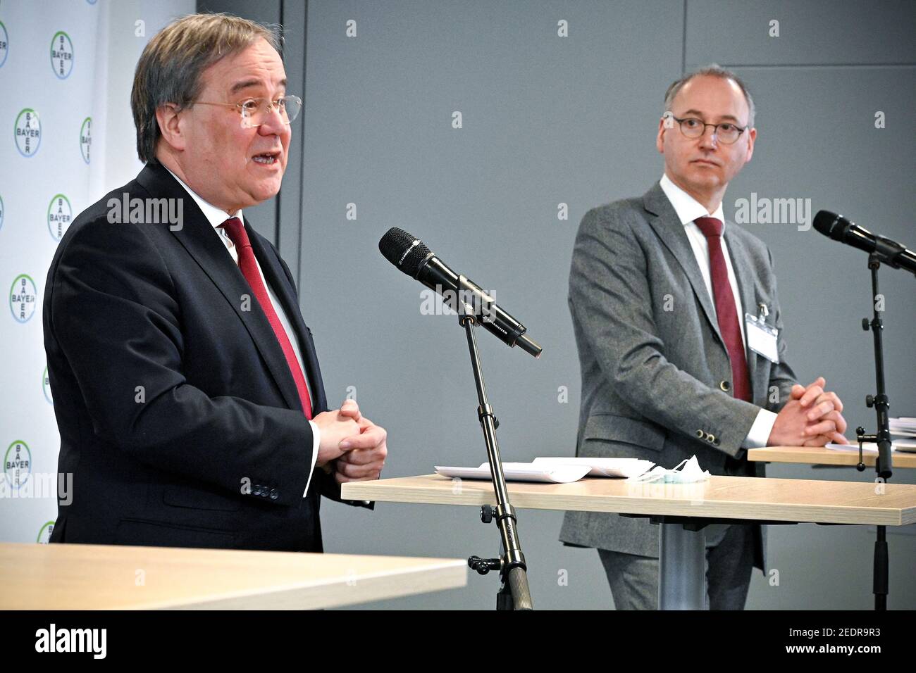 Wuppertal, Germania. 15 Feb 2021. Armin Laschet (l, CDU), Ministro Presidente della Renania Settentrionale-Vestfalia, e Werner Baumann, Presidente del Consiglio di Amministrazione della società farmaceutica tedesca Bayer AG, nel corso di una conferenza stampa dopo la visita al futuro sito di produzione del vaccino corona CVnCoV di CureVac presso lo stabilimento Bayer AG. La produzione del vaccino CureVac avverrà presso il centro biotecnologico Bayer di Wuppertal, tra le altre strutture. Credit: Sascha Steinbach/EPA POOL/dpa/Alamy Live News Foto Stock