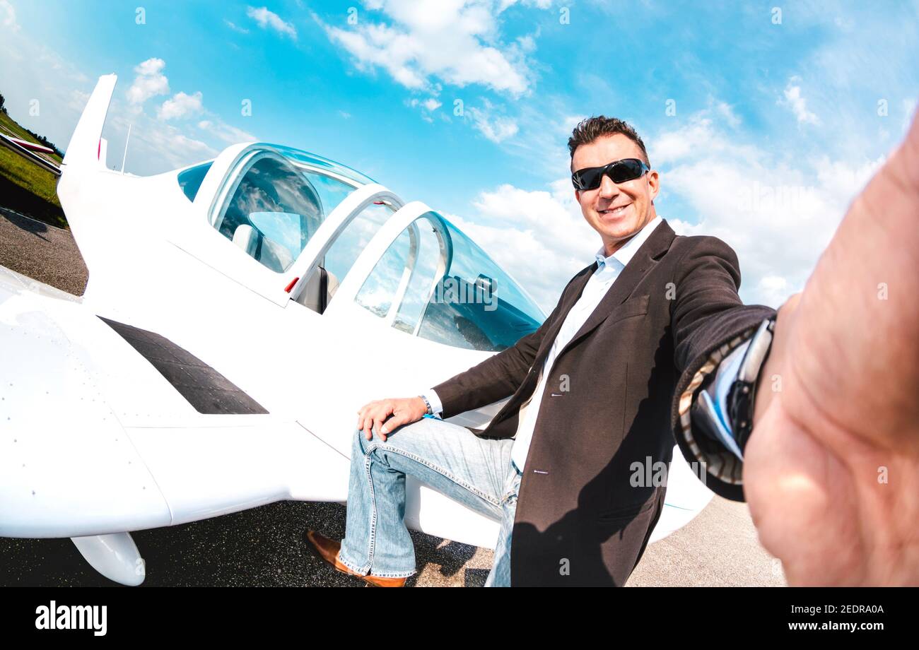 Giovane uomo sicuro che prende selfie con smartphone mobile a. Aereo privato - concetto di business moderno con un ragazzo ricco pronto per escursioni di lusso Foto Stock