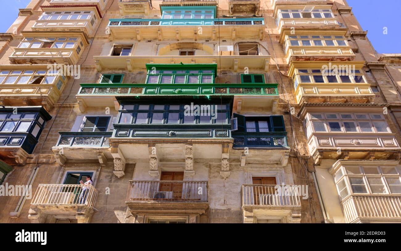 Tradizionali balconi in legno maltese e finestre su un appartamento residenziale Edificio nel centro di Valletta Malta Foto Stock
