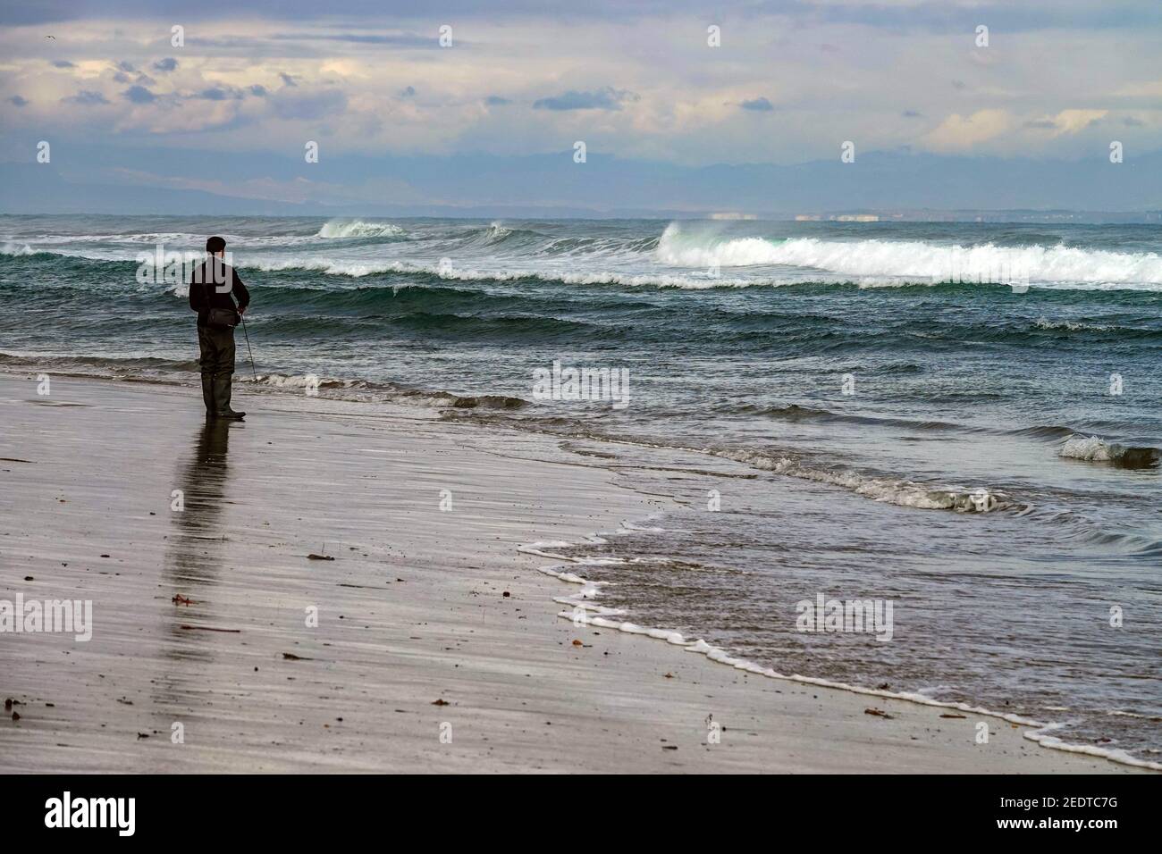 Lone pescatore in inverno presso la località costiera di la Mata, Torrevieja, Costa Blanca, Spagna Foto Stock