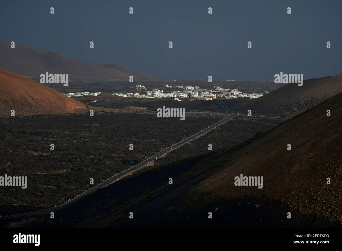 Bellissimo paesaggio vulcanico e la piccola città di Mancha Blanca la mattina presto a Lanzarote, Isole Canarie, Spagna. Il calima vento si fa un surrea Foto Stock