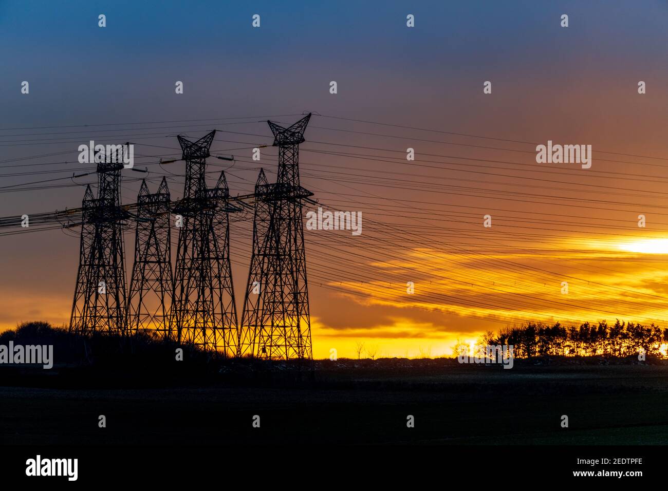 Torre elettrica ad alta tensione sul tramonto e cielo sullo sfondo del tramonto. Torre elettrica Foto Stock