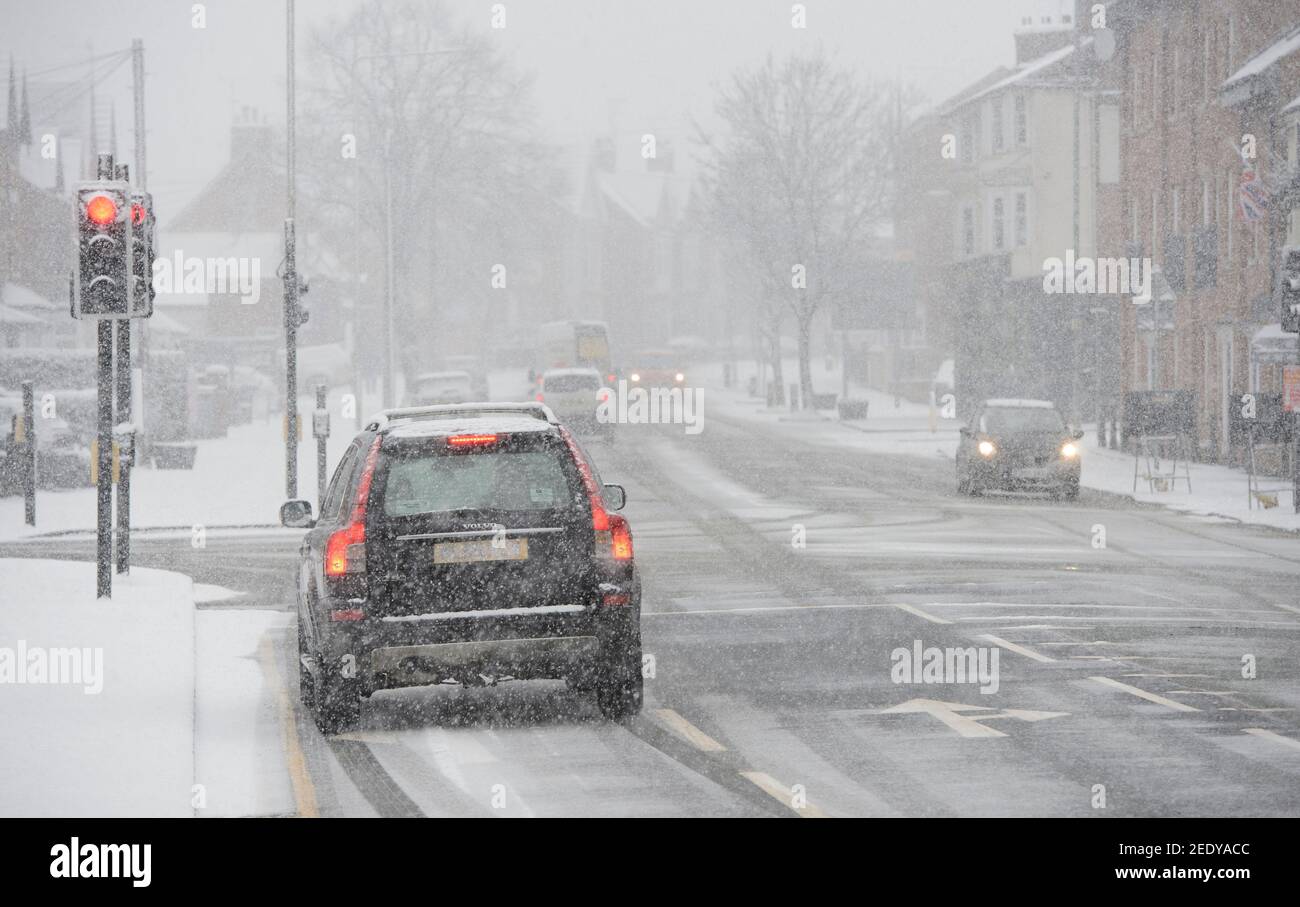 Veicoli che guidano in condizioni di neve in Market Harborough, Leicestershire, East Midlands, Inghilterra. Foto Stock