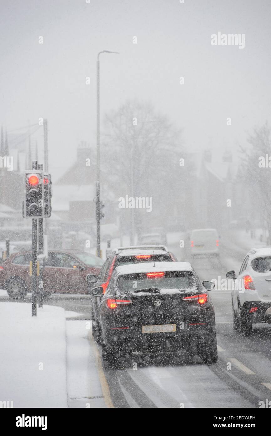 Veicoli che guidano in condizioni di neve in Market Harborough, Leicestershire, East Midlands, Inghilterra. Foto Stock
