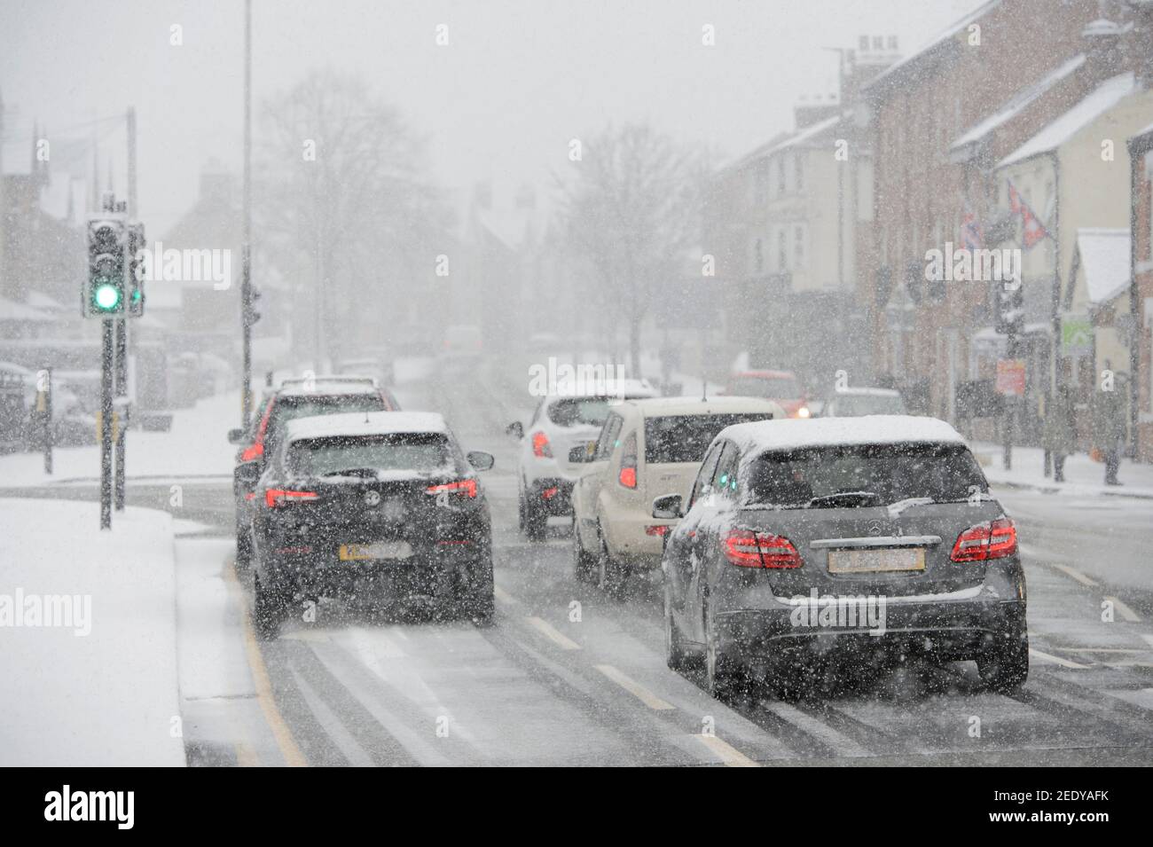 Veicoli che guidano in condizioni di neve in Market Harborough, Leicestershire, East Midlands, Inghilterra. Foto Stock