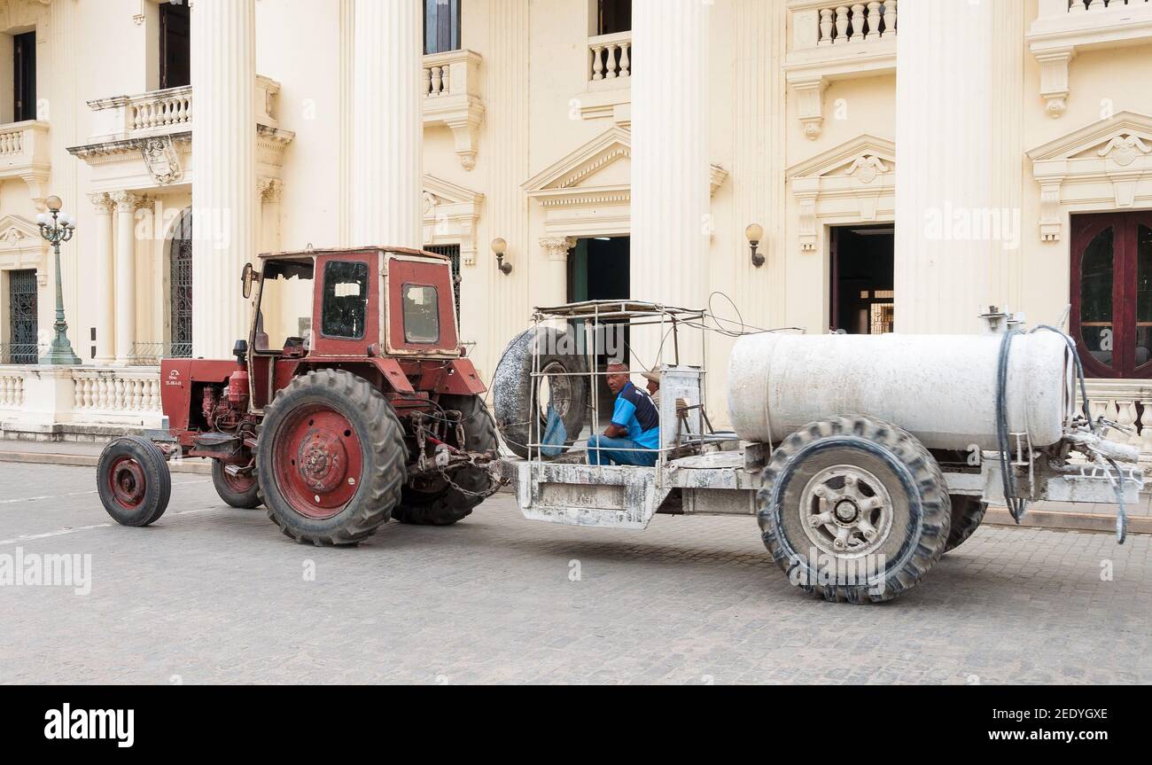 Obsoleto trattore russo utilizzato per dipingere le strade di una città cubana, il veicolo d'epoca sta passando di fronte alla biblioteca provinciale Jose Marti Foto Stock