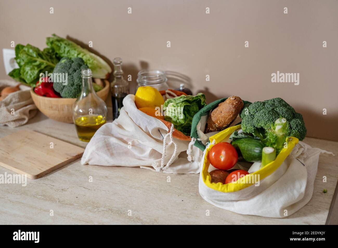 Sacchetti riutilizzabili in cotone con prodotti alimentari e oggetti in vetro tavolo da cucina Foto Stock