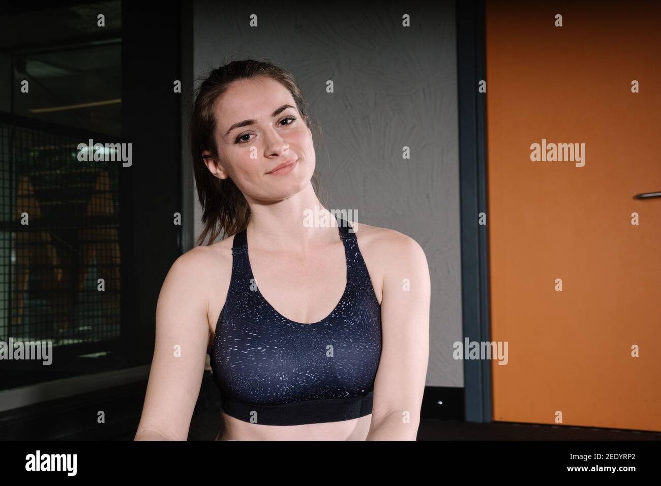 Bella giovane donna in palestra. La donna che si allenano in palestra pone per la macchina fotografica. Nella foto è presente un'area di scrittura. Foto Stock