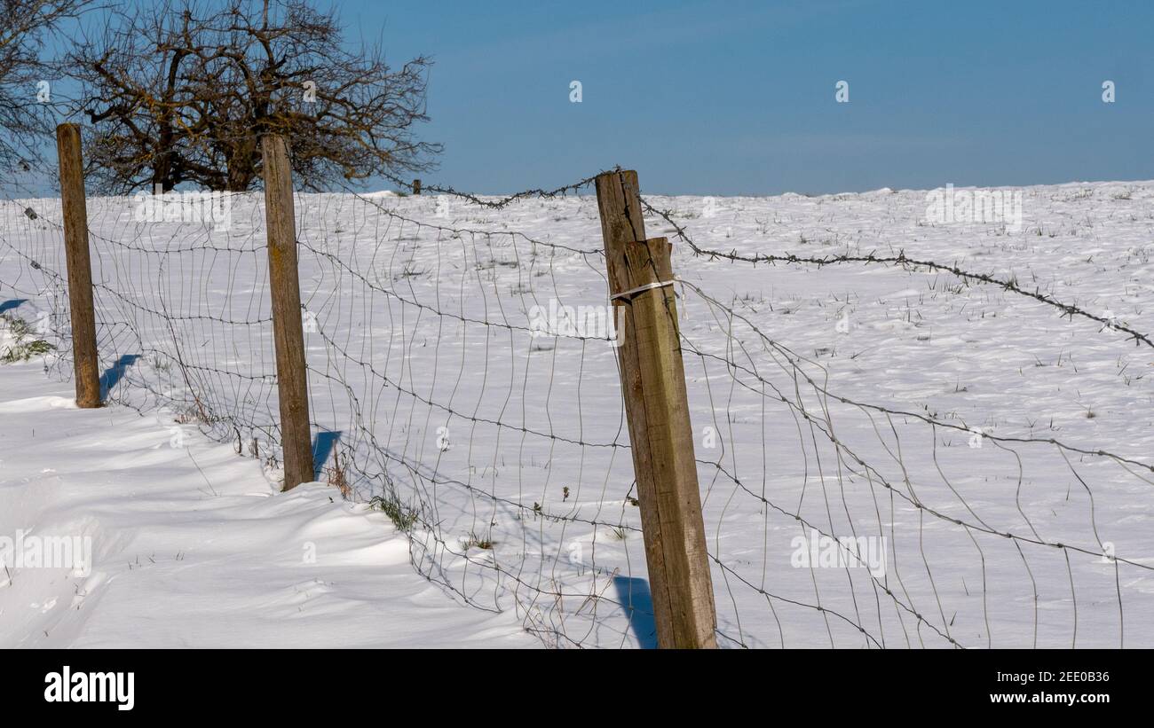 Vista di una recinzione nel campo innevato Foto Stock