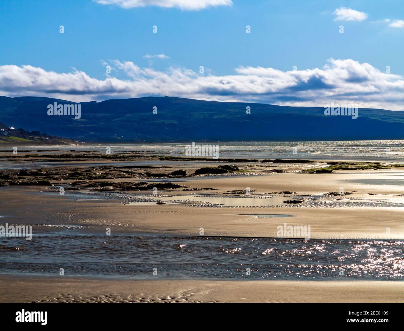 La spiaggia di sabbia di Barmouth Bay o Abermaw a Gwynedd sulla costa nord occidentale del Galles con le montagne di Snowdonia in distanza. Foto Stock