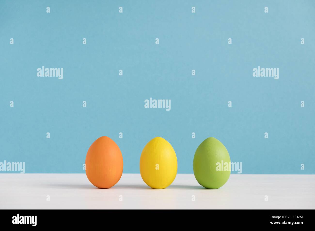 Uova colorate su sfondo azzurro. Buon passato di Pasqua. Pasqua minima. Foto Stock