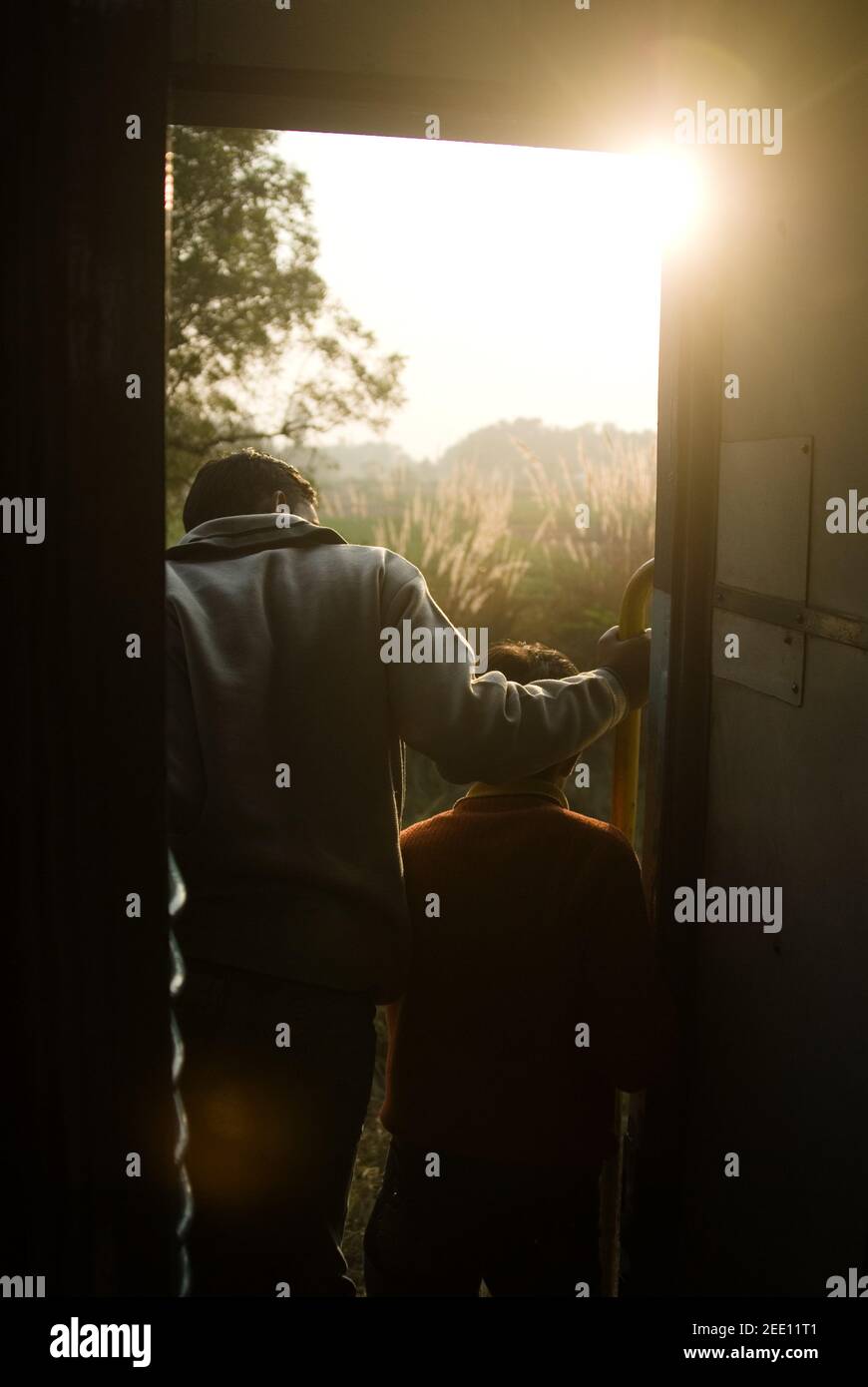 Uomo e ragazzo guardando fuori la finestra di un treno, Agra, India Foto Stock