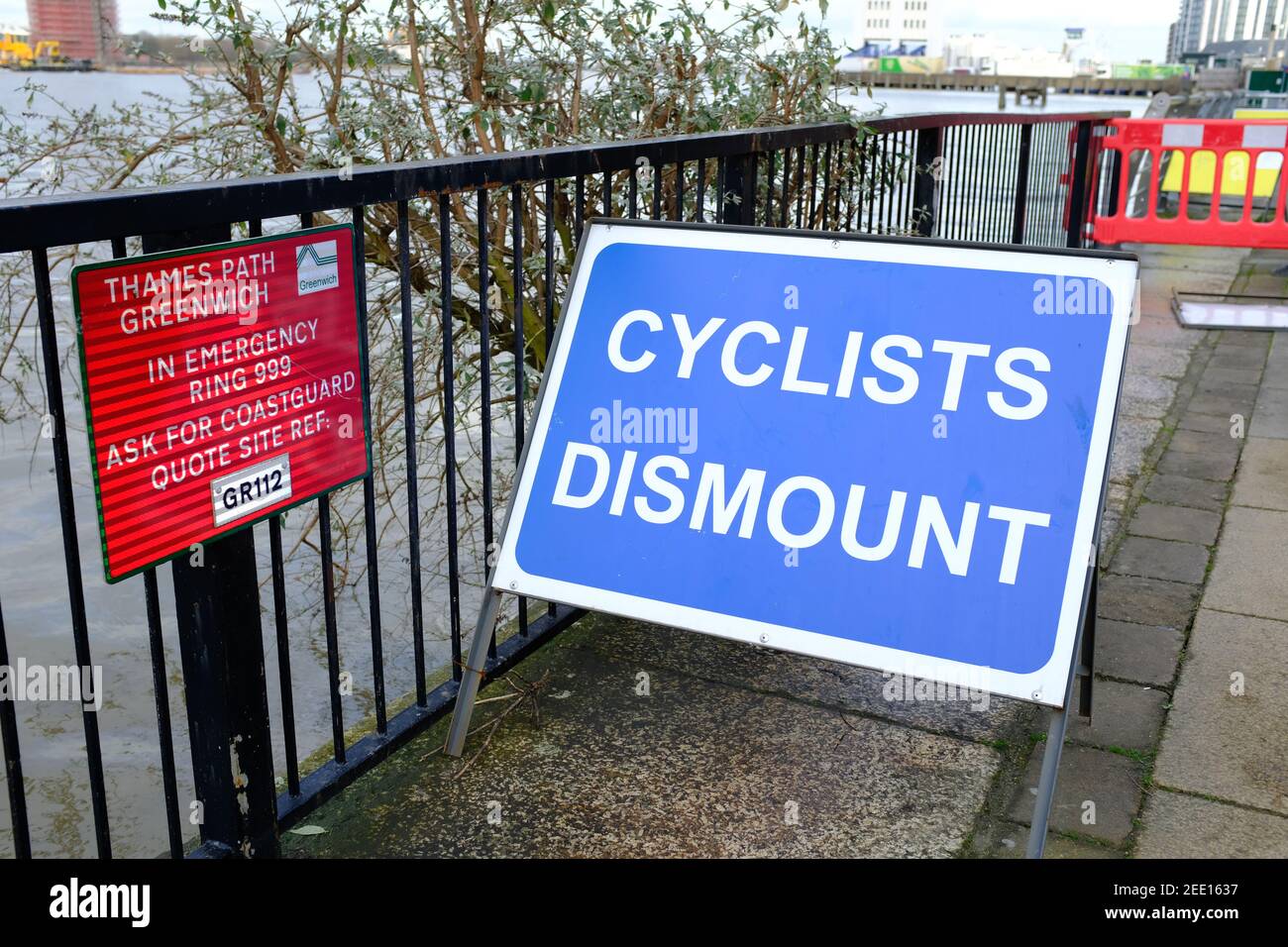 LONDRA - 15 FEBBRAIO 2021: Un ciclista smonta il cartello sul Tamigi a Woolwich. Foto Stock