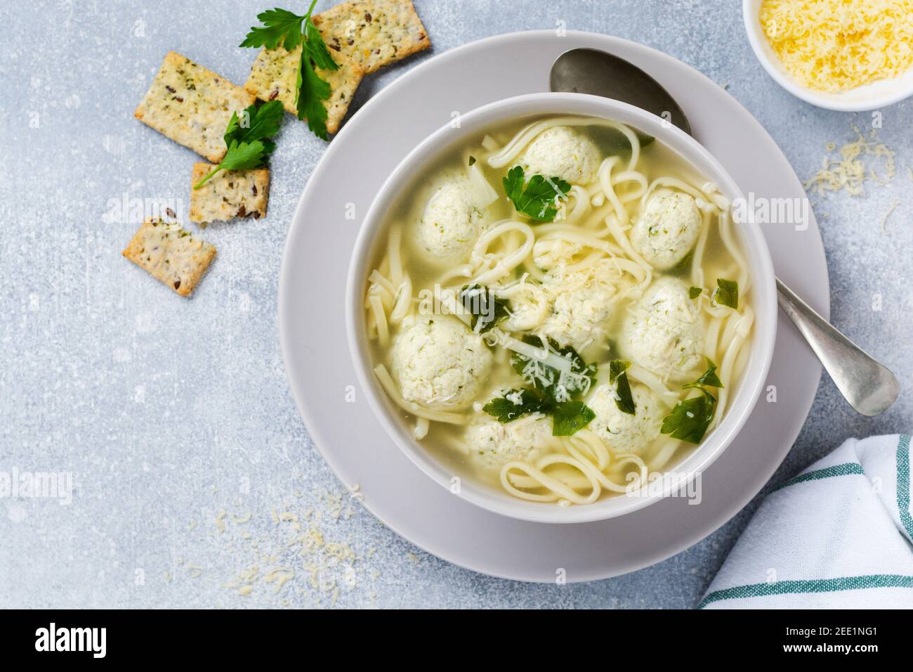 Zuppa con polpette di pollo e pasta all'uovo con parmigiano e prezzemolo. Cibo italiano per bambini con pasta e carne. Cucina italiana tradizionale. Foto Stock