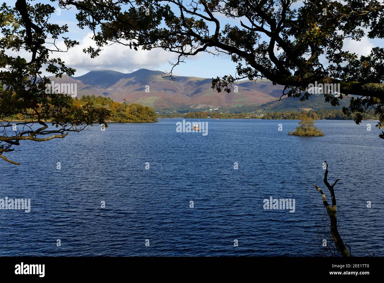 Montagne lontane e traghetto locale sul Distretto dei Laghi d'acqua di Derwent Cumbria Foto Stock
