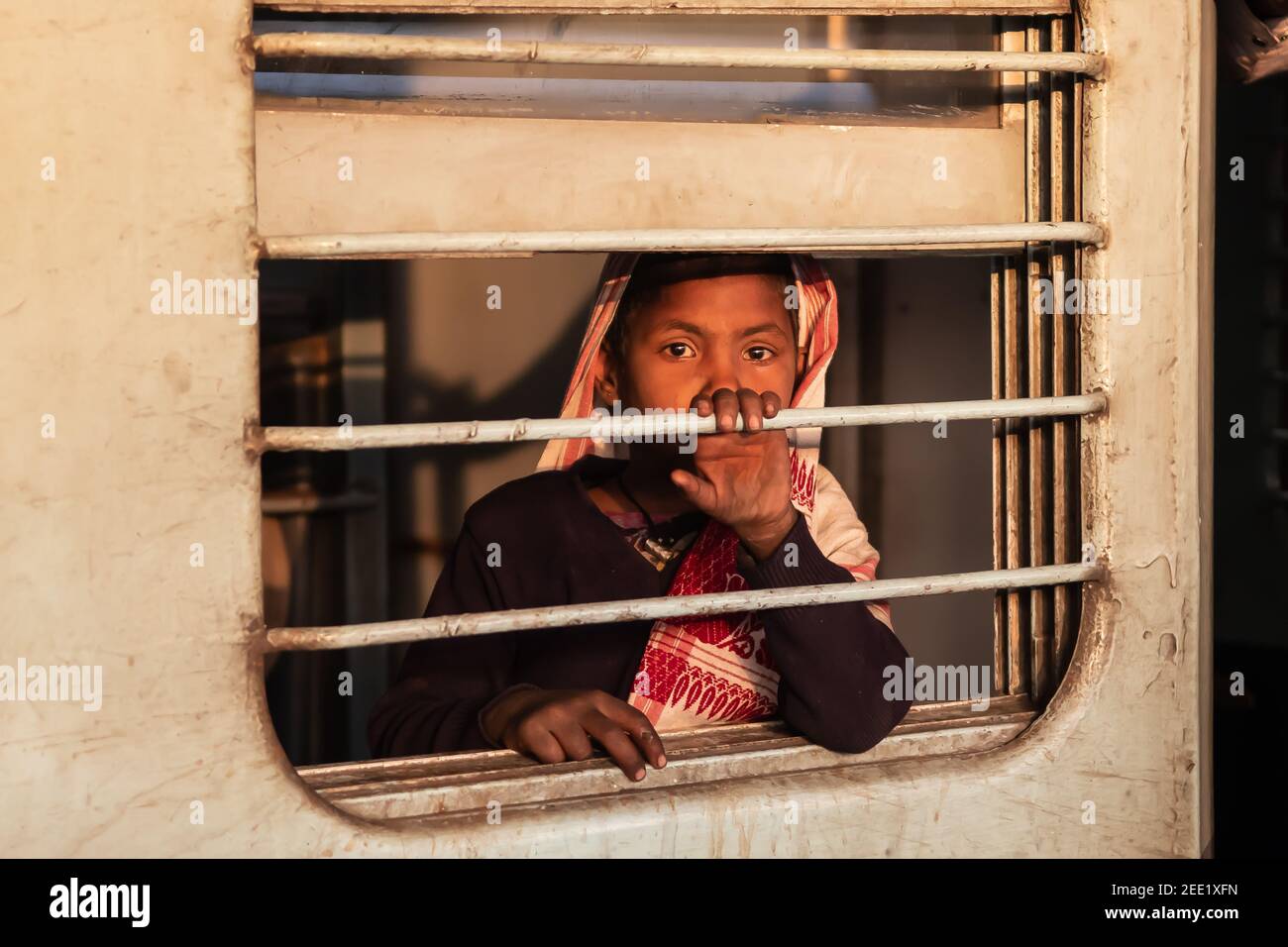 Varanasi. India. 05-02-2018. La giovane ragazza che viaggia in treno guarda la finestra mentre si ferma alla stazione ferroviaria di Varanasi. Foto Stock