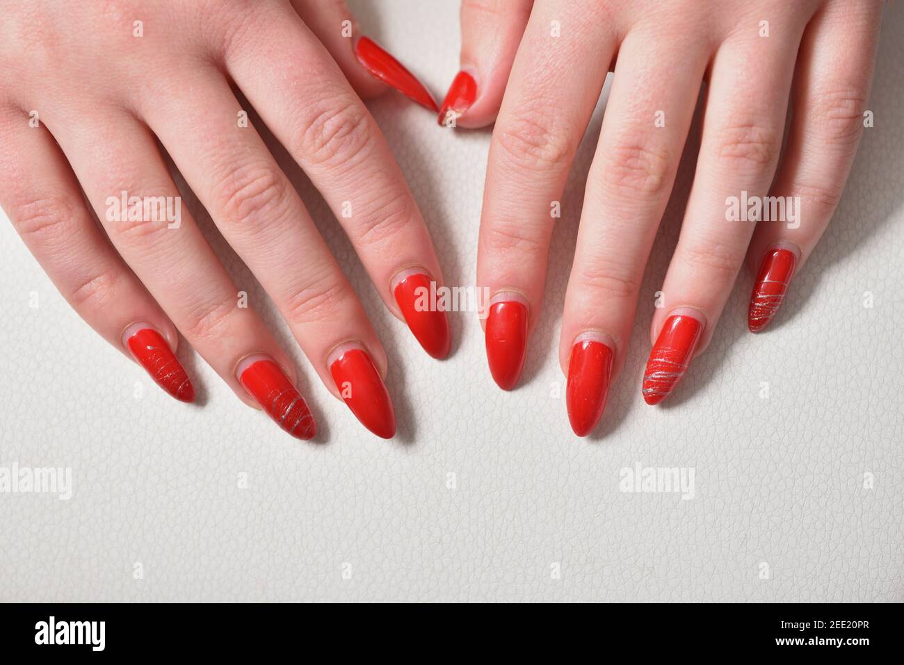 Mani femminili con chiodi in gel rosso riccrescita da vicino Foto Stock