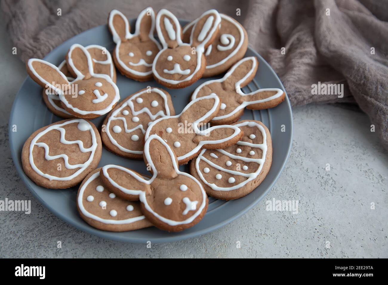 Biscotti di cioccolato sotto forma di coniglietti e uova per La vacanza di Pasqua su un piatto grigio e una pietra sfondo Foto Stock