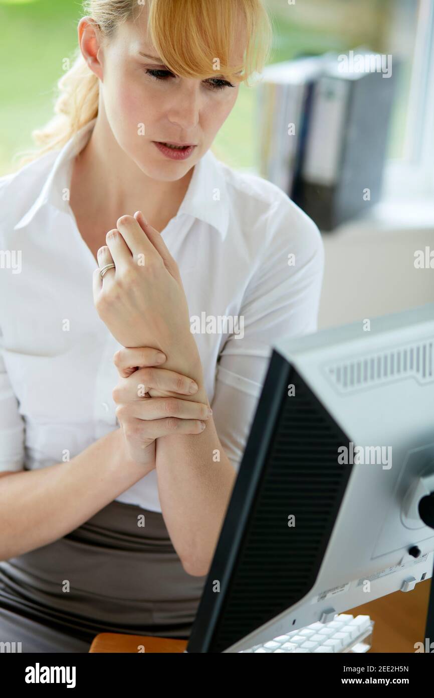 Donna che tiene il polso doloroso Foto Stock