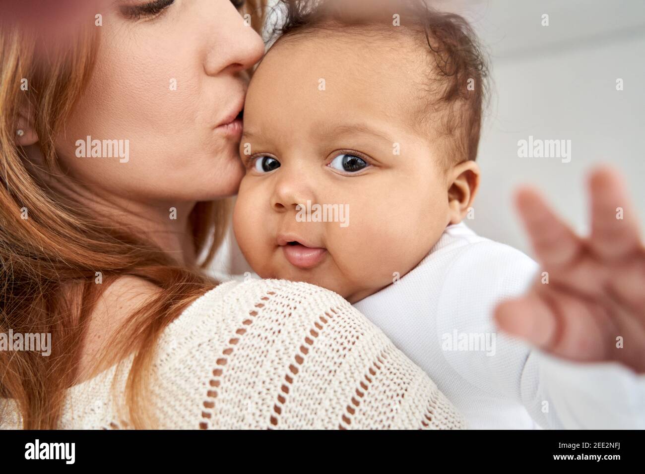 Carino adorabile bambino afro-americano figlia che si diverte nelle braccia delle mamme. Foto Stock