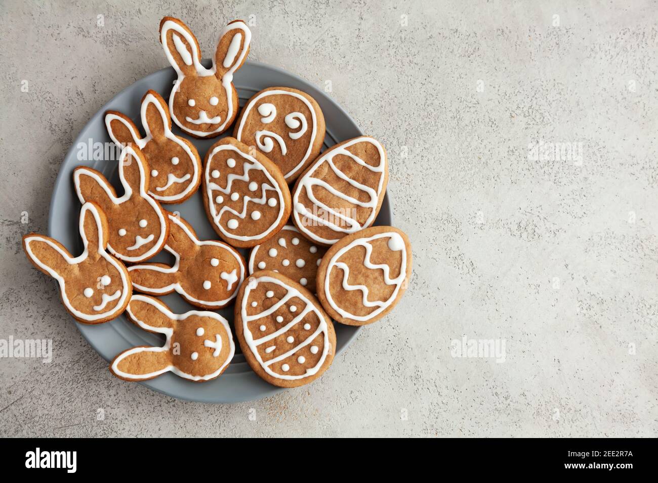 Biscotti di Pasqua sotto forma di coniglietti e uova Una piastra grigia e uno sfondo in pietra grigia, vista dall'alto e. spazio di copia Foto Stock
