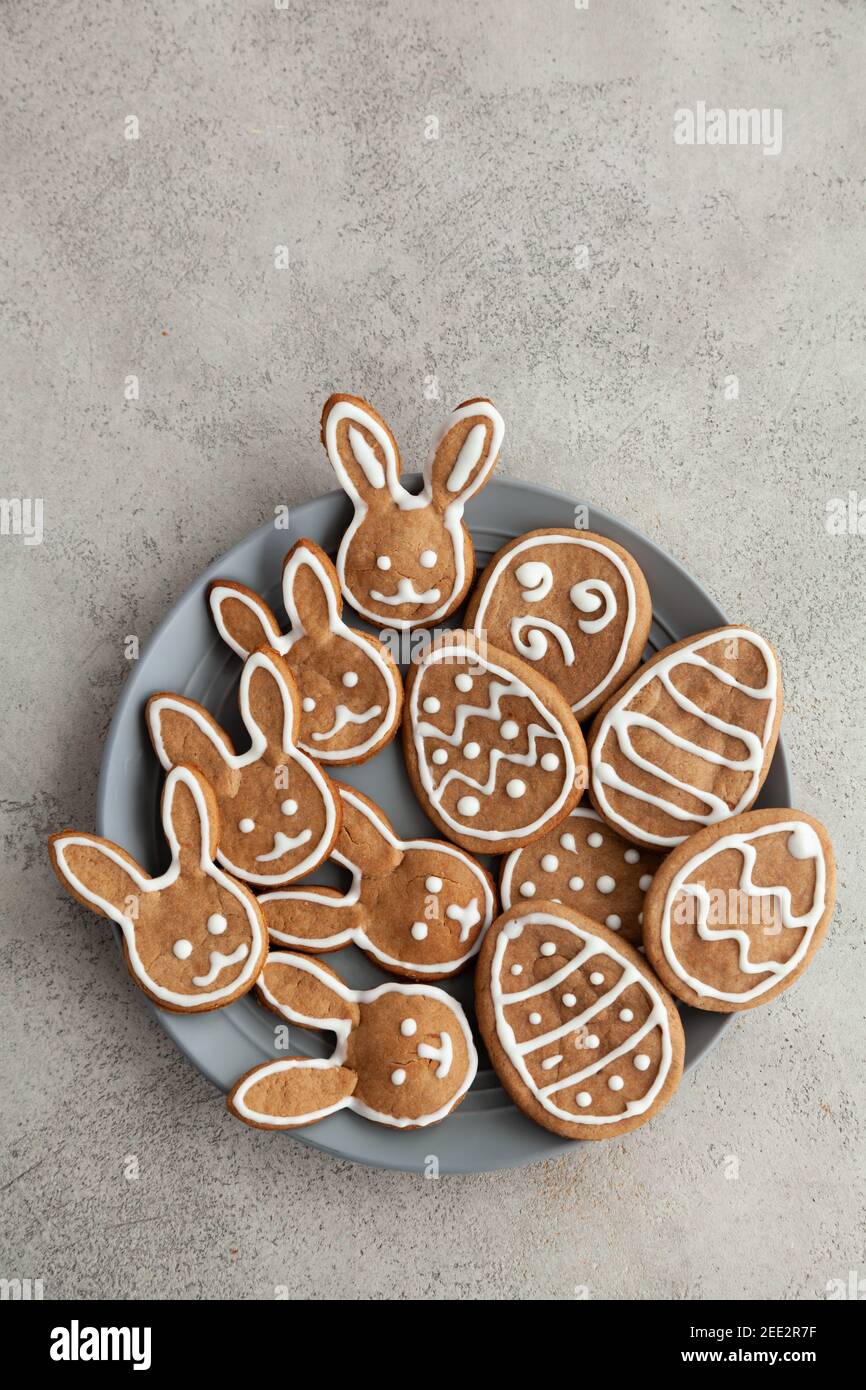 Biscotti di Pasqua sotto forma di coniglietti e uova Una piastra grigia e uno sfondo in pietra grigia, vista dall'alto e. spazio di copia Foto Stock