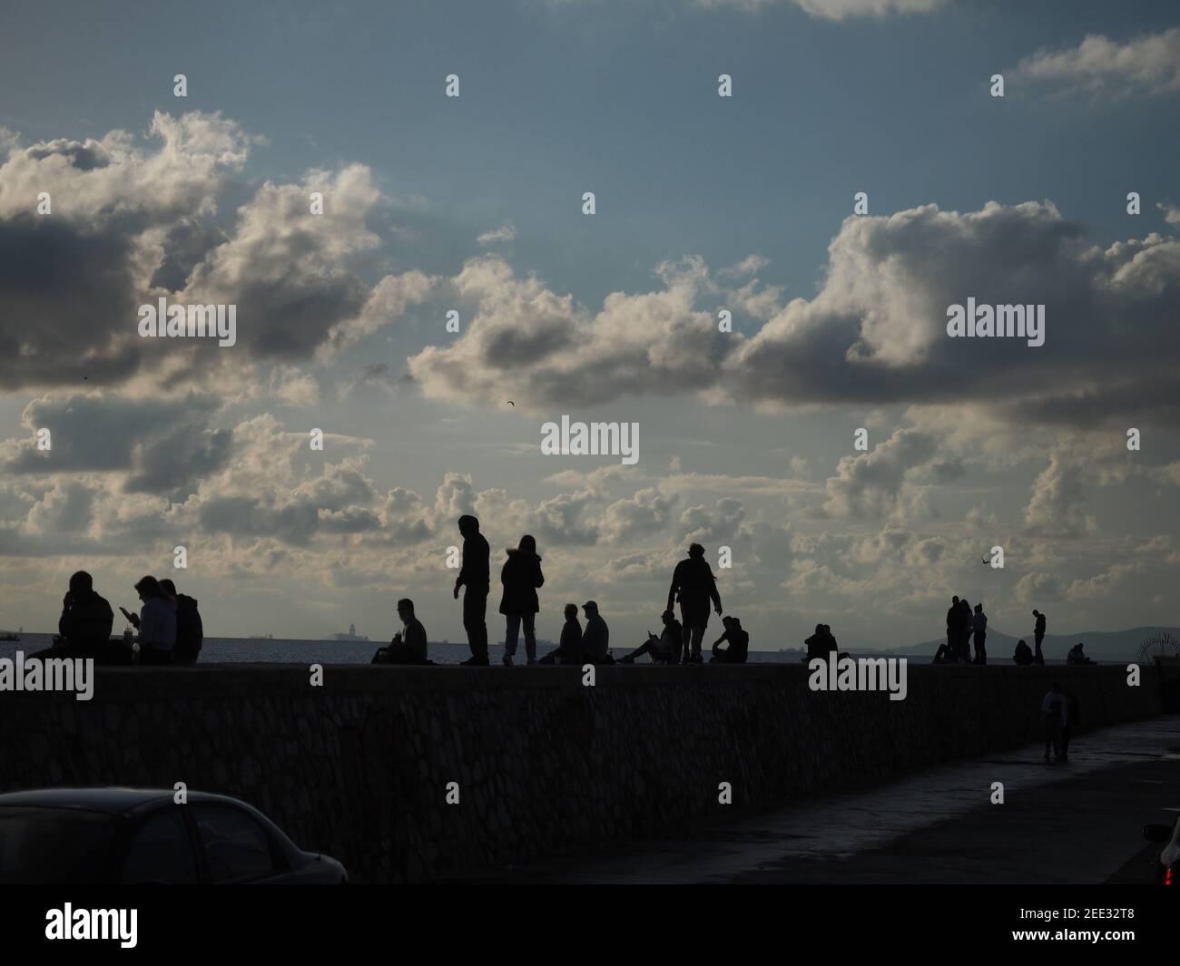 Amici e famiglie che si rilassano sul lungomare in inverno Foto Stock Amici e famiglie che si rilassano sul lungomare in inverno Foto Stock