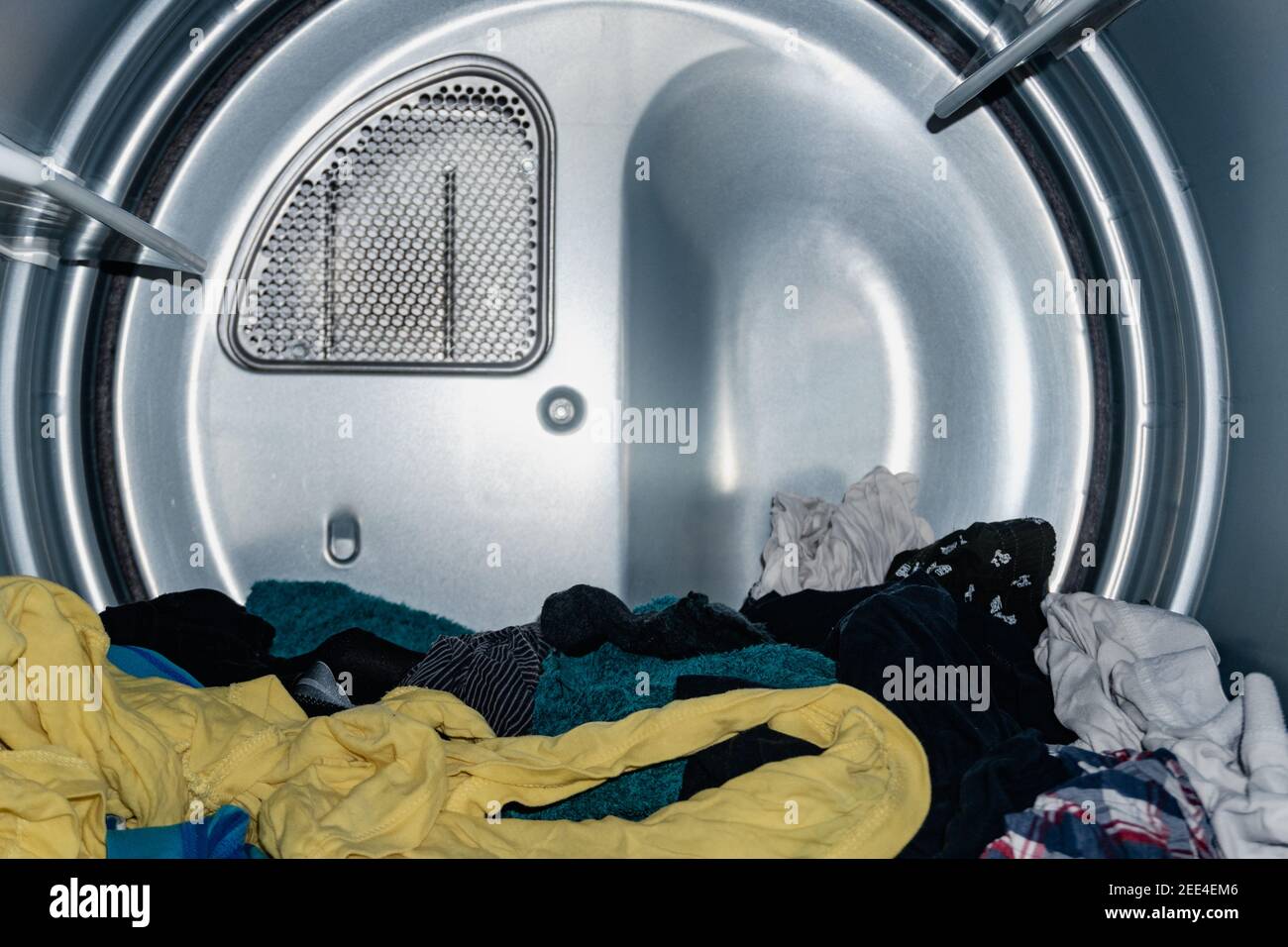 vestiti di molti colori che asciugano nell'asciugatore, già lavati nella lavatrice. asciuga industriale. asciuga domestico. asciuga veloce. vista dall'interno Foto Stock