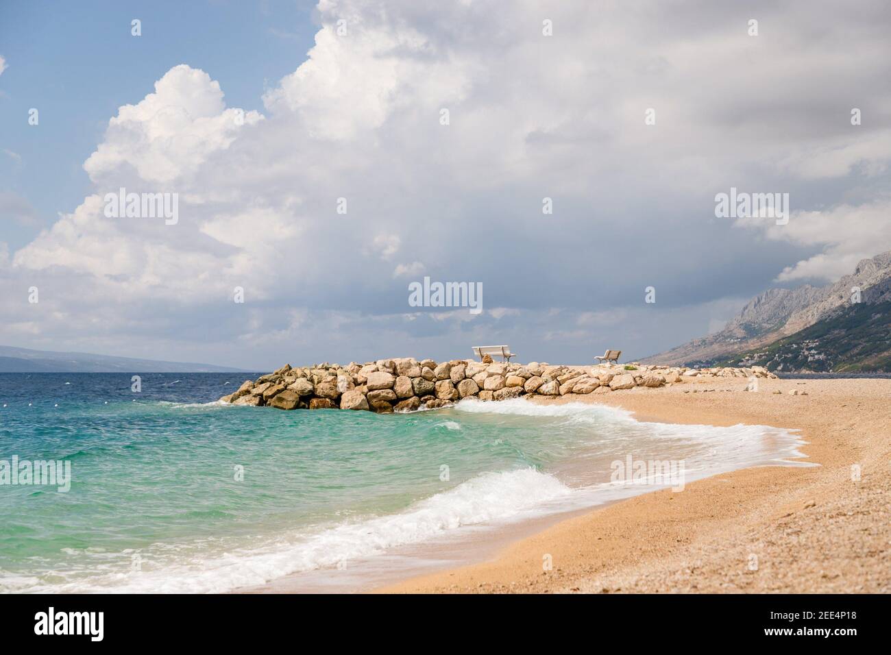 Bellissimo molo, panchine e acqua di mare smeraldo. Brela Croazia, riviera di Makarska Foto Stock