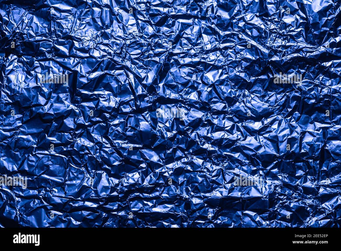 Sfondo in lamina blu con superficie sminuzzata lucida per lo sfondo texture. Lamina rugosa della superficie iridescente. Foto Stock