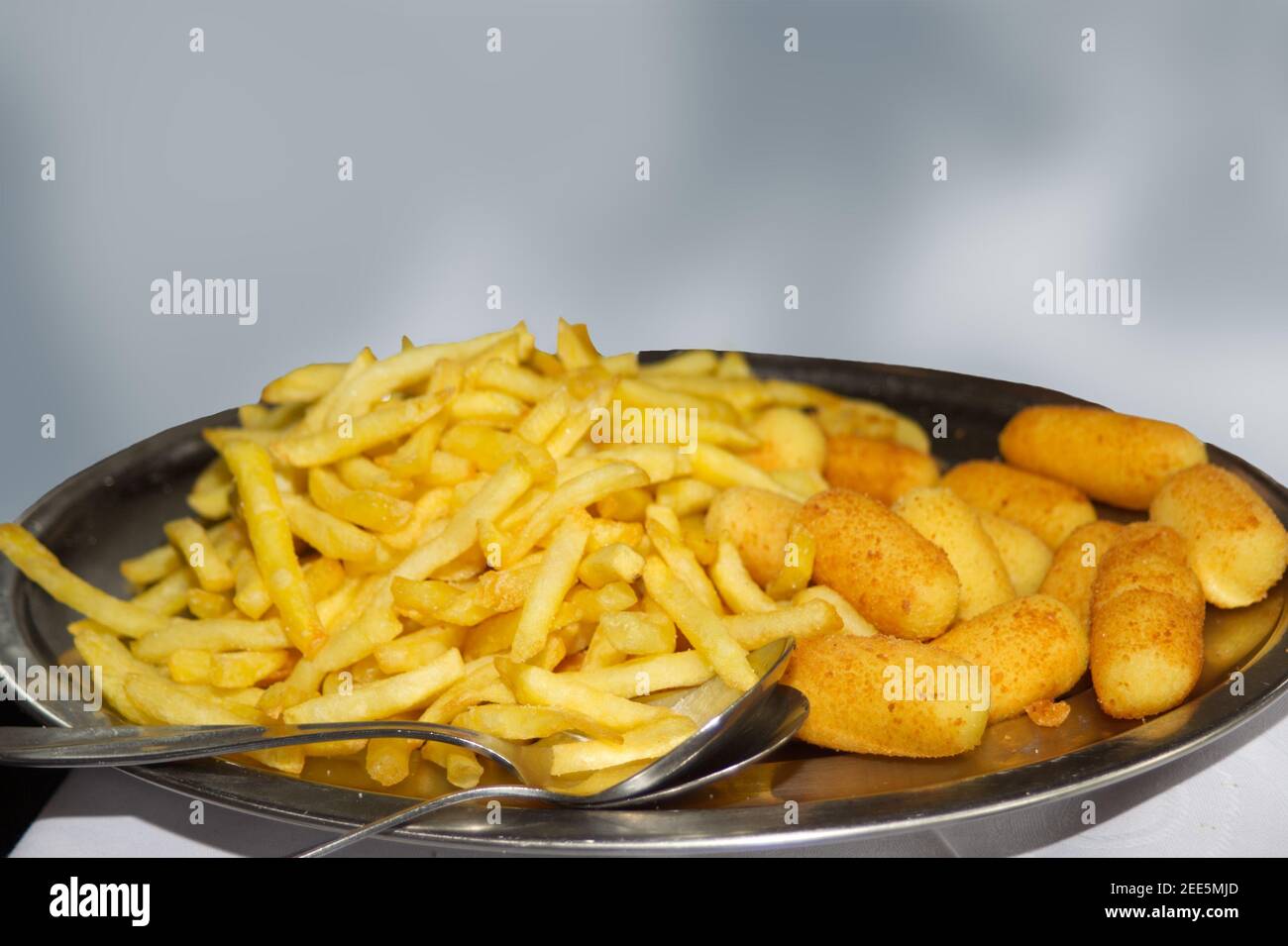 Patatine fritte e crocchette su piatto in ristorante isolato Foto Stock