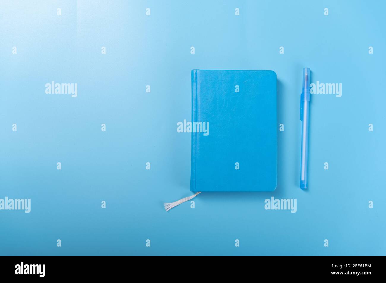 Blocco note e penna su sfondo blu. Blocco note, penna e sfondo in blu. In alto. Foto Stock