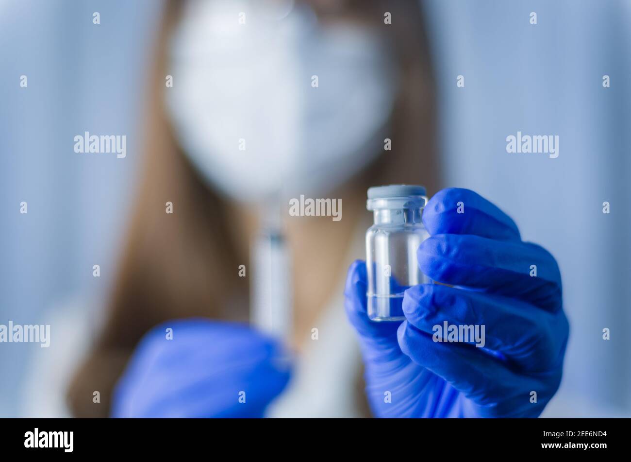 Medico femminile con stetoscopio su siringa con supporto per spalla e vaccino COVID-19. Concetto sanitario e medico. Foto Stock