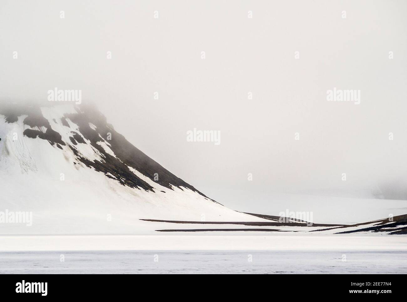 Una gelida banca di nebbia che scende su un'isola oceanica artica, parte dell'arcipelago Franz Josef Foto Stock