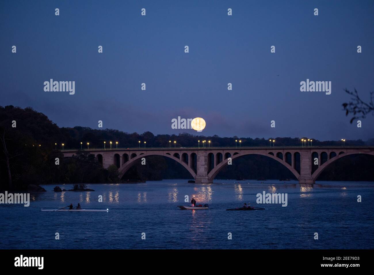 La luna piena si affaccia sul fiume Potomac e sul Key Bridge, che collega Arlington, Virginia e Washington, DC. Foto Stock
