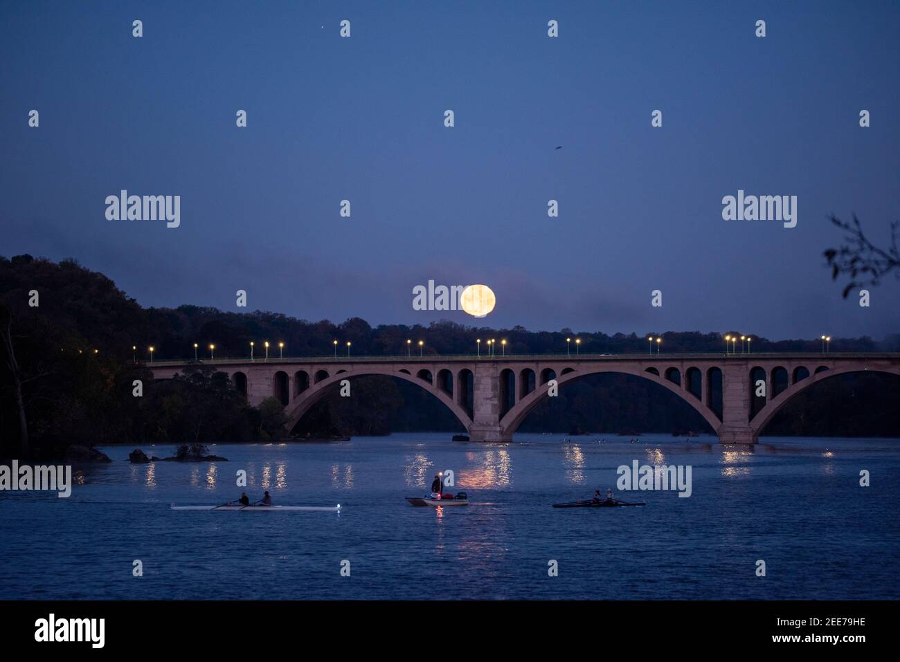 La luna piena si affaccia sul fiume Potomac e sul Key Bridge, che collega Arlington, Virginia e Washington, DC. Foto Stock