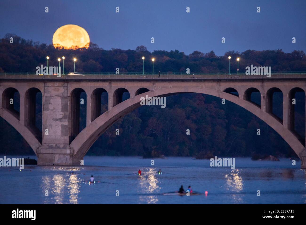 La luna piena si affaccia sul fiume Potomac e sul Key Bridge, che collega Arlington, Virginia e Washington, DC. Foto Stock