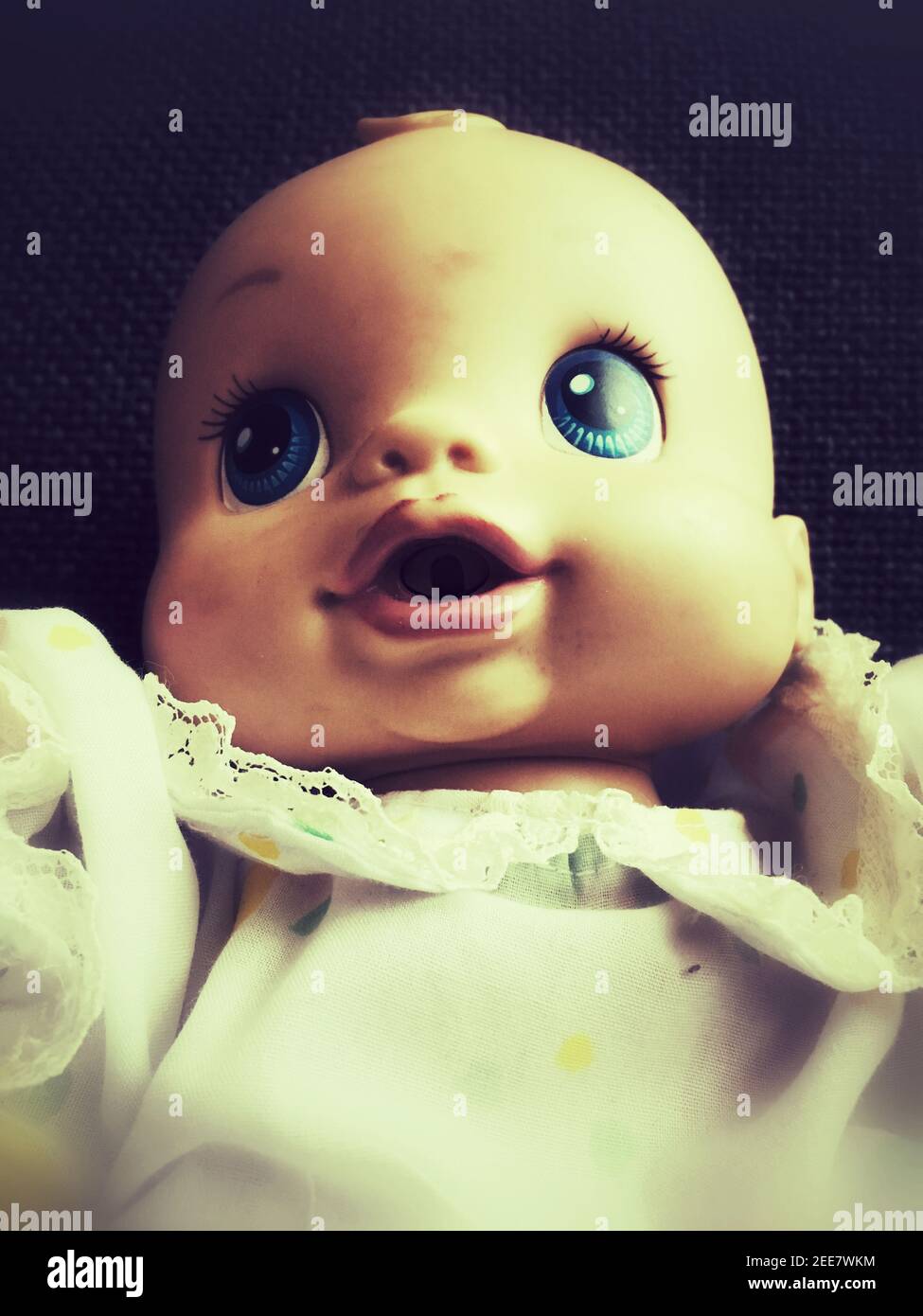 Una vista ravvicinata degli occhi e del volto di a. bambola giocattolo femminile in plastica dall'aspetto strano in un abito Foto Stock