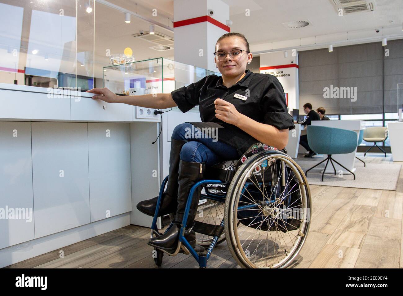 MINSK, BIELORUSSIA - Gennaio 2021: Una persona con disabilità su sedia a rotelle lavora come barista in una caffetteria inclusa. Il barista prepara il caffè nella sua caffetteria al lavoro. Un progetto unico, una caffetteria inclusiva. Un luogo in cui tutti i dipendenti sono disabilitati. Gestito da una persona con sindrome di Down. Tutti i baristi sono disattivati. Questo è Natasha Astanina. Ha 25 anni. È un utente della sedia a rotelle fin dall'infanzia. Il barista funziona. È stato impegnato nella danza sportiva dall'età di 13. È appassionato di paracadutismo. Per 10 salti di paracadute. Foto Stock