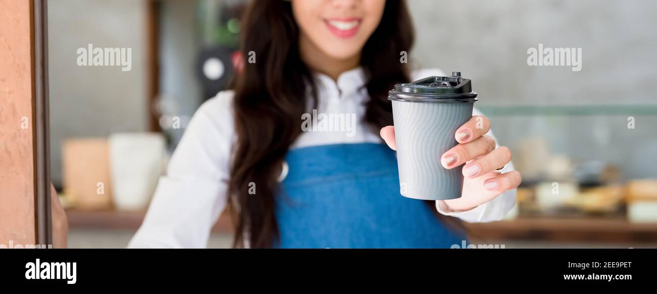 Giovane donna che dà la tazza di caffè da asporto al cliente al caffè, banner panoramico con spazio per la copia Foto Stock