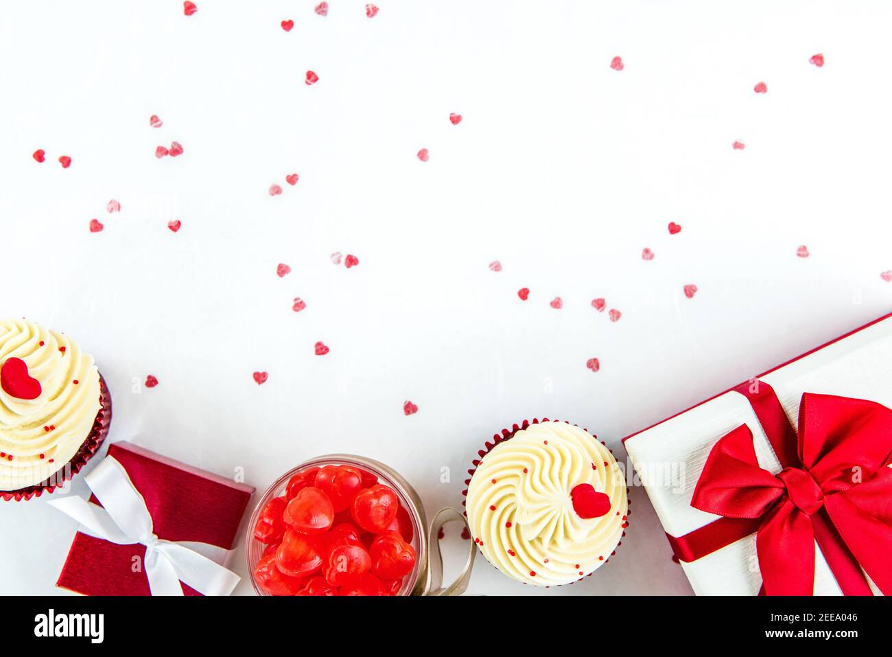 Scatole regalo con caramelle a forma di cuore e cupcake di velluto rosso su carta bianca, San Valentino o concetti di sfondo matrimonio Foto Stock