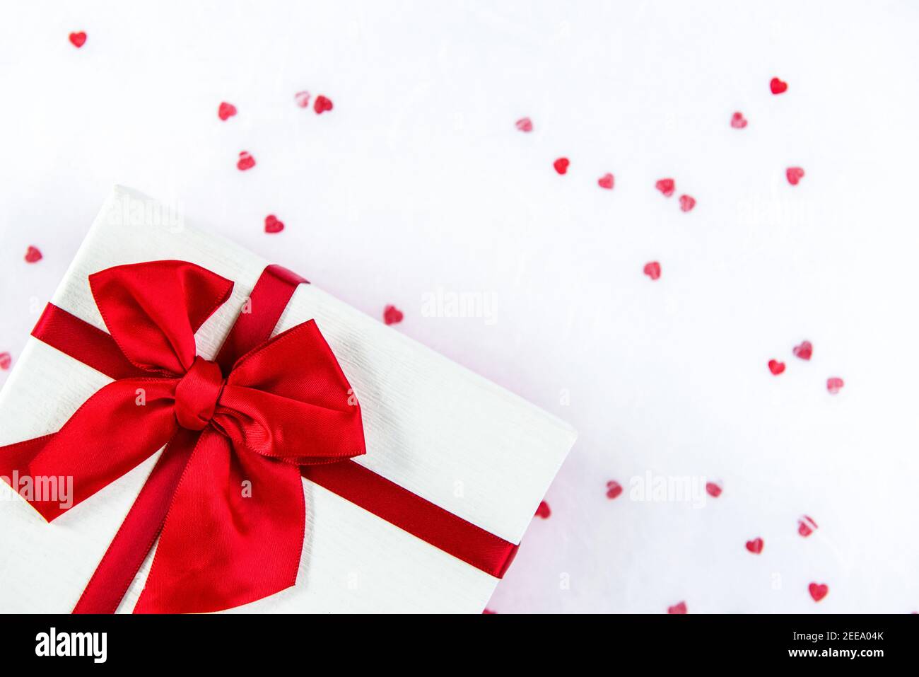 Confezione regalo per San Valentino o matrimonio su sfondo bianco con motivo a forma di cuore rosso, vista dall'alto con spazio per la copia Foto Stock