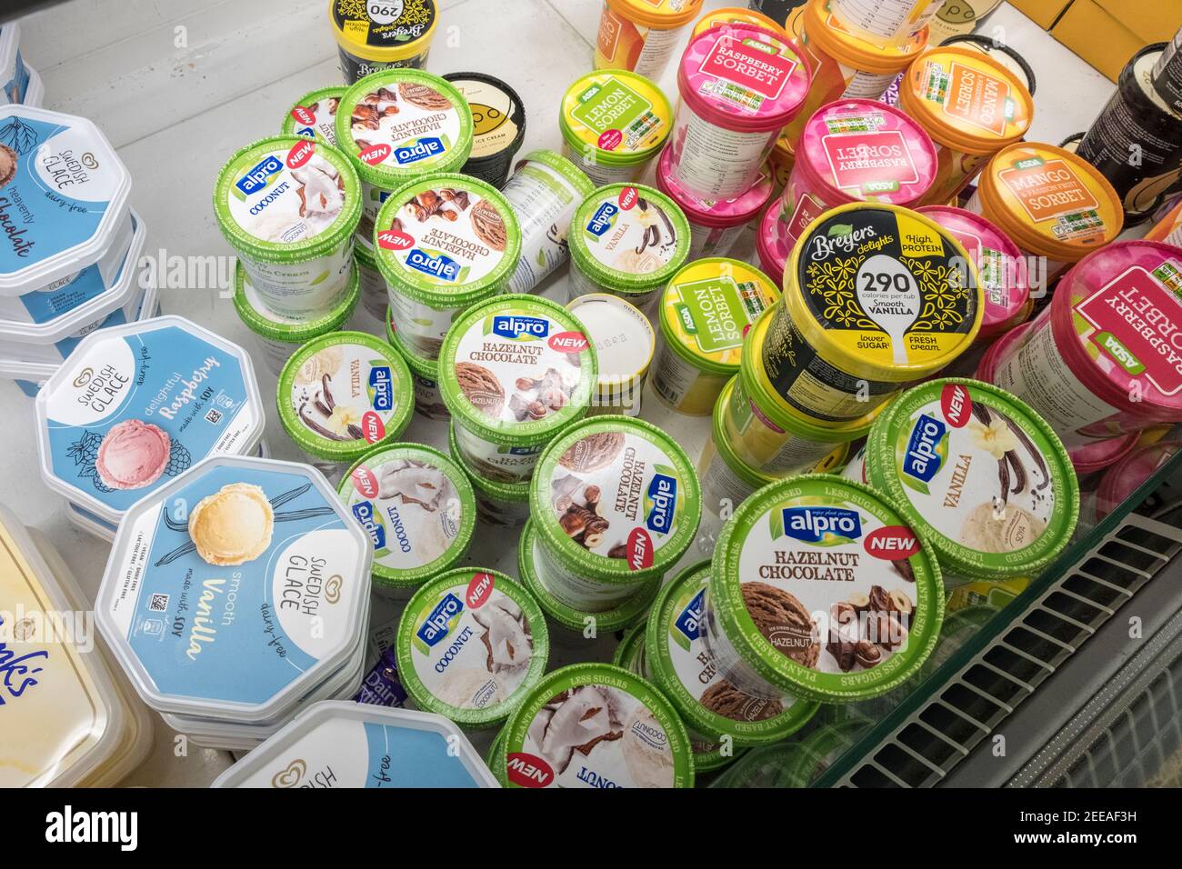 Selezione di gelati e sorbetti senza latte, vegani, senza lattosio, senza glutine e a base di soia nel congelatore del supermercato Foto Stock