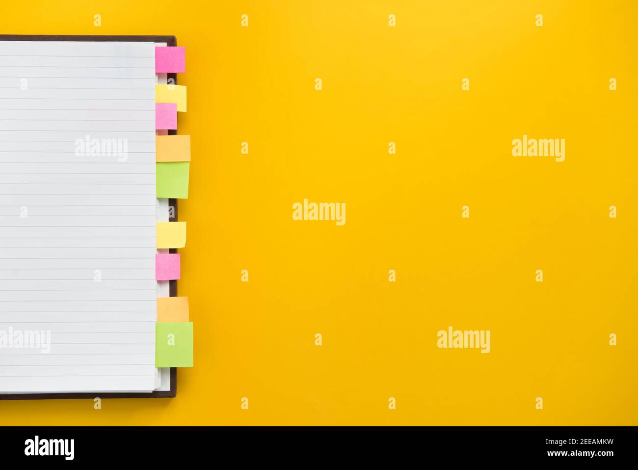 Apri un notebook vuoto con segnalibri adesivi colorati su carta gialla, design del bordo del concetto di sfondo educativo con spazio per la copia Foto Stock