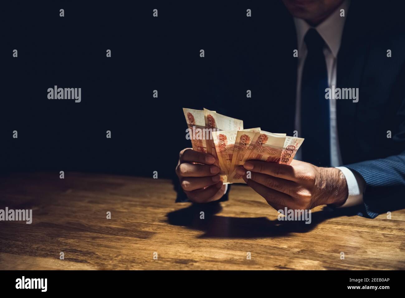 Uomo d'affari in camera oscura contando i soldi, valuta rublo russa Foto Stock