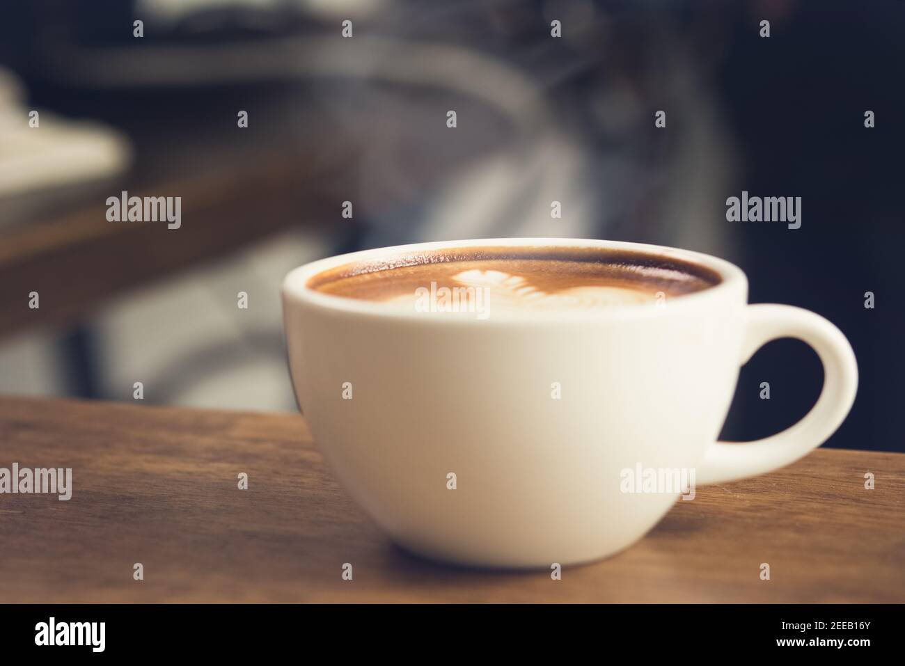 Caffè caldo appena fatto nella tazza sul tavolo di legno pronto a bere Foto Stock