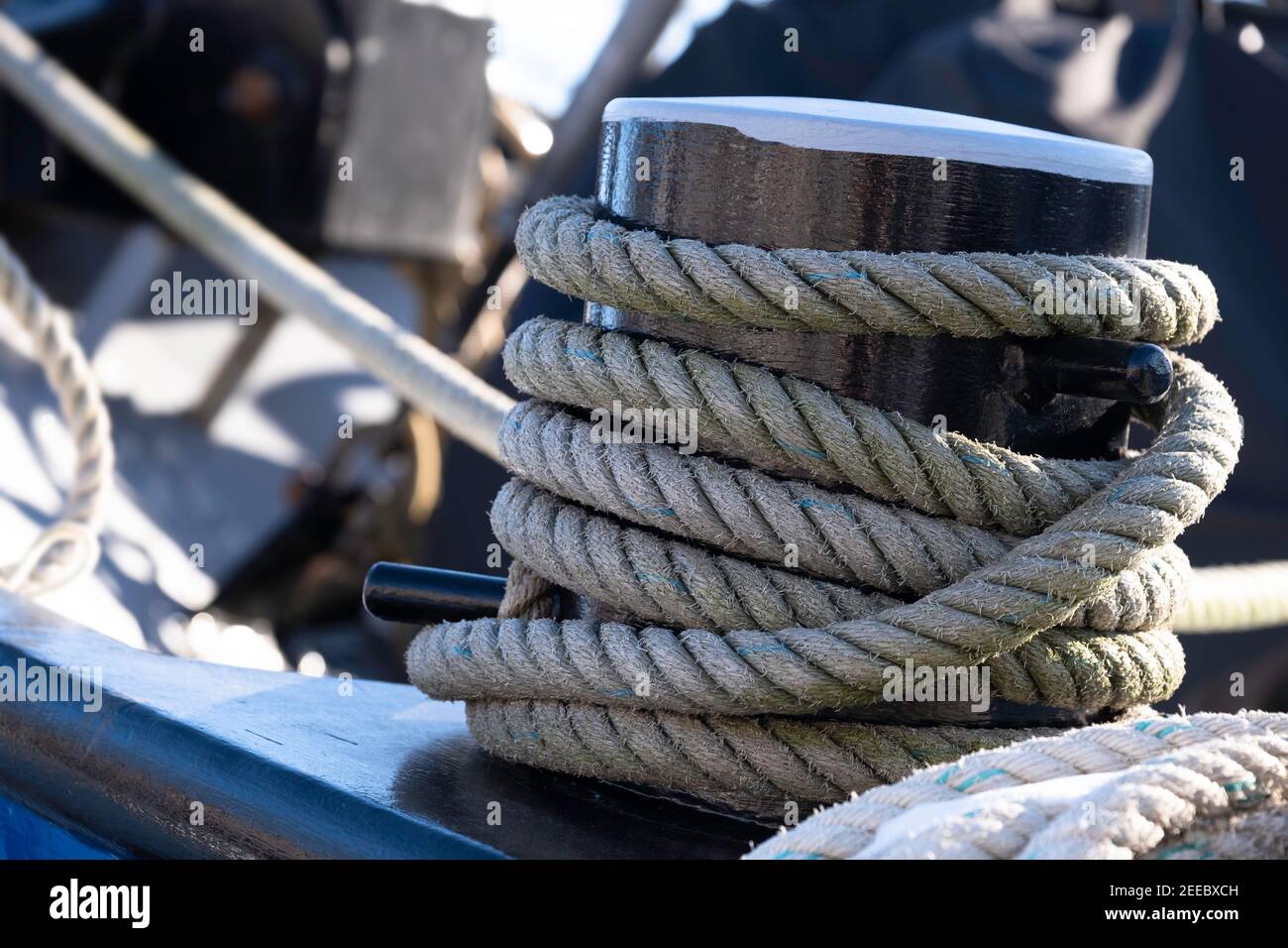 Corda spessa della nave con neve su di loro intorno al tollard sulla prua di un cargo di metallo ormeggiato a Lemmer, Paesi Bassi. Mettere a fuoco la corda Foto Stock