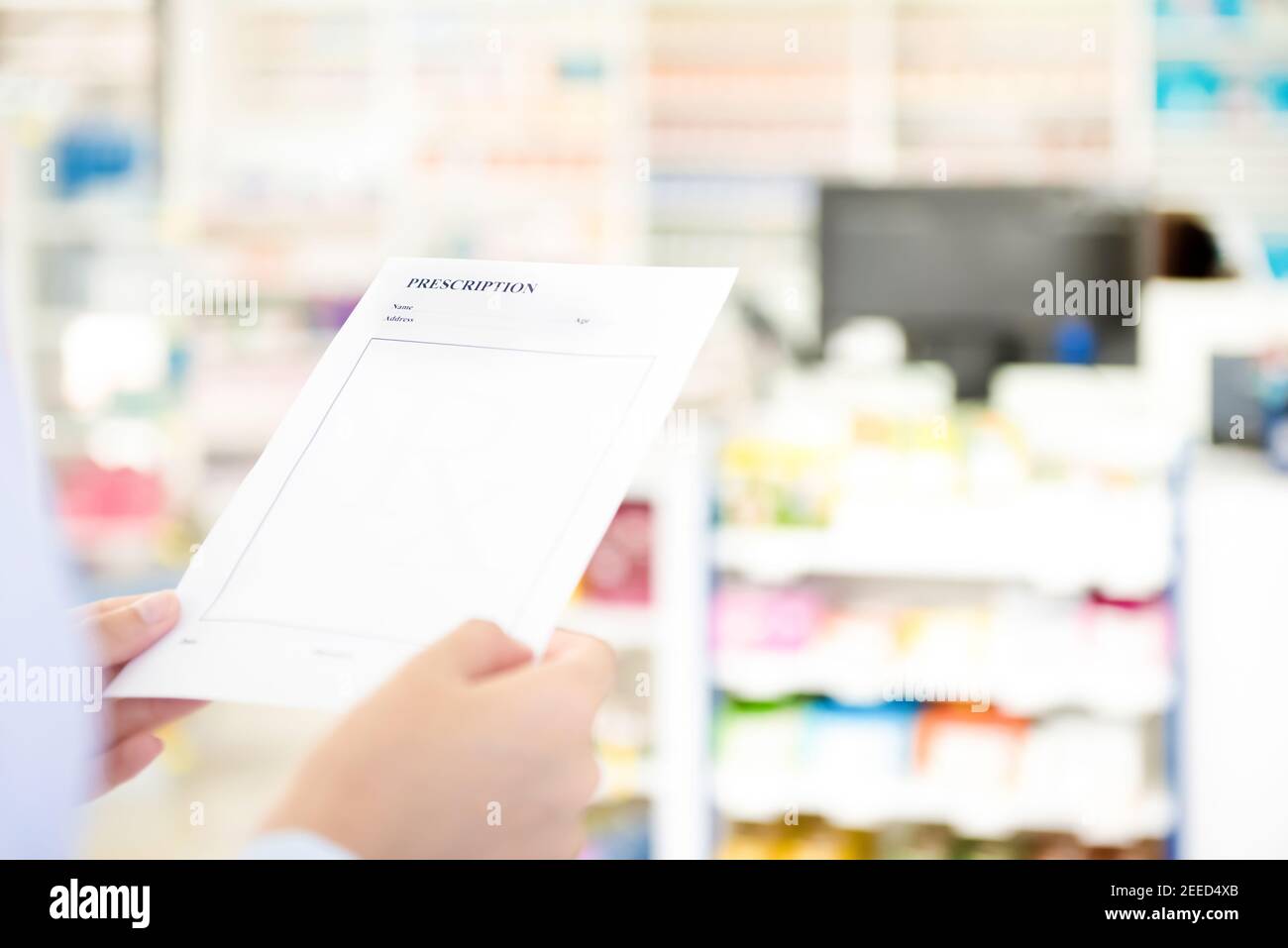 Mani del farmacista femminile che tiene e guardando la prescrizione RX carta in farmacia Foto Stock